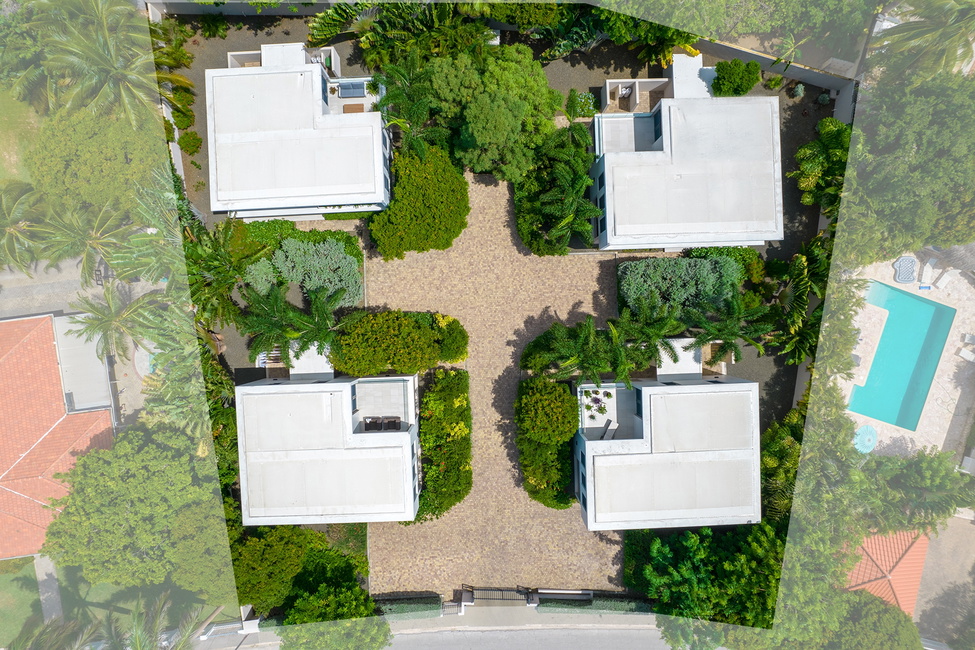 The four buildings each with their two car-parking area and gardens as seen from above within the lot.